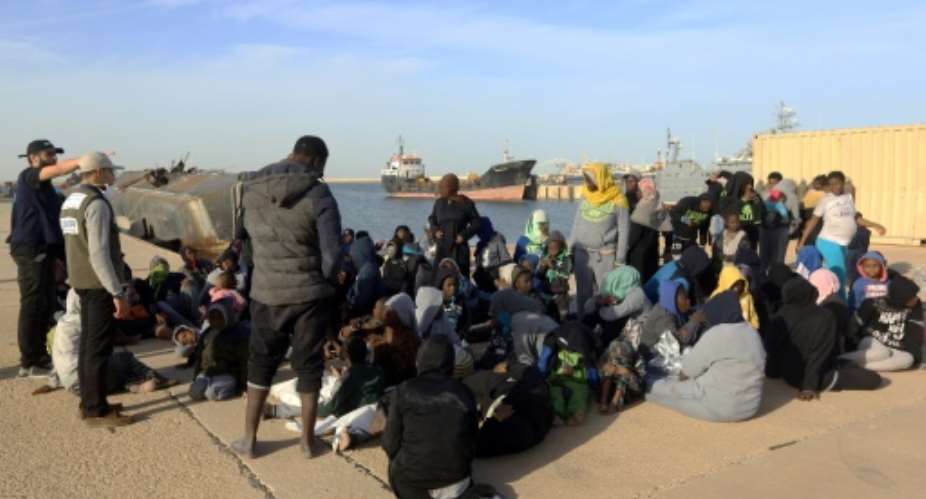 Migrants wait at a naval base in the Libyan capital Tripoli January 7, 2018, after being rescued off the Libyan coast of Garabulli, east of the capital.  By MAHMUD TURKIA AFP