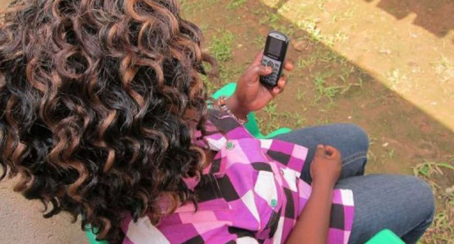 HIV-positive health worker Stella Nayiga, 28, checks her text messages.  By Max Delany AFPFile