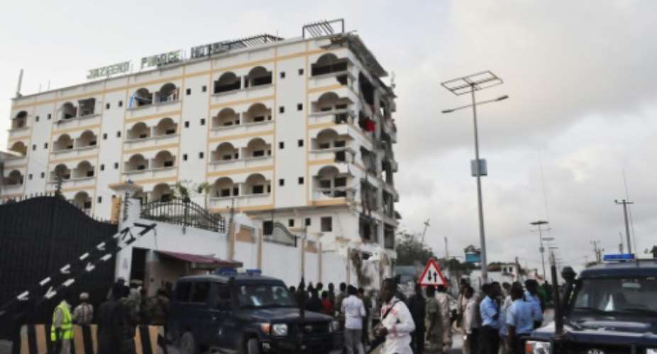 People stand in front of the damaged Jazeera Palace hotel following a suicide attack in Mogadishu on July 26, 2015.  By - AFPFile