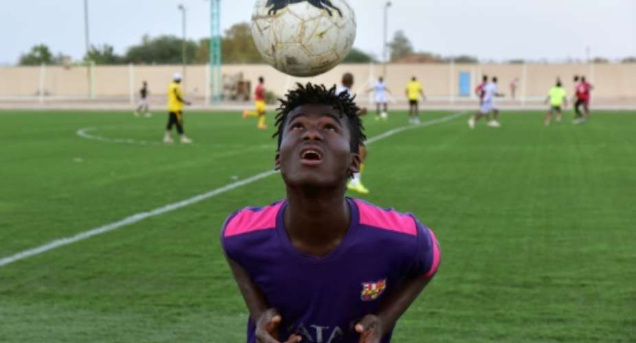 Mohamed Diaby, a 16-year-old from Ivory Coast who hopes to migrate to Europe, training with Nassara Agadez, a team in Niger's second division.  By ISSOUF SANOGO AFP