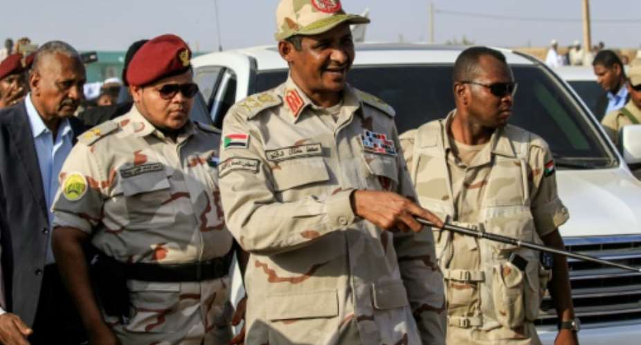 Mohamed Hamdan Dagalo C, deputy head of Sudan's ruling Transitional Military Council TMC and commander of the Rapid Support Forces RSF paramilitaries, is escorted through the village of Qarri, north of Khartoum, on June 15, 2019.  By Ashraf SHAZLY AFP