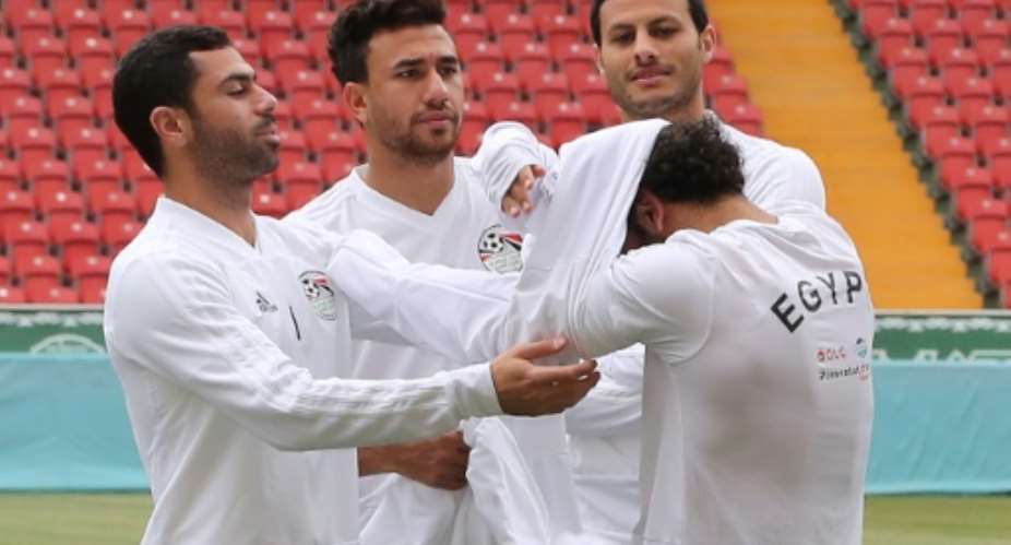 Mohamed Salah needed the help of three teammates to put on a training top.  By KARIM JAAFAR AFP
