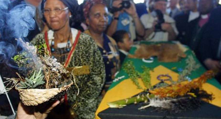 Traditional herbs are burnt around the coffin bearing the remains of Sarah 'Saartjie' Baartman at a ceremony on her arrival at the airport in Port Elizabeth, South Africa, August 8, 2002.  By Anna Zieminski AFPFile