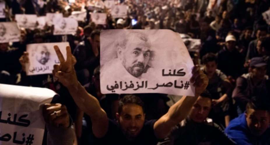 Moroccan demonstrators hold pictures of protest leader Nasser Zefzafi in the city of Al-Hoceima on May 29, 2017 following his arrest.  By FADEL SENNA AFPFile