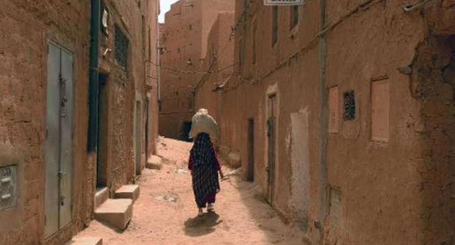 A Moroccan woman carries a sack on her head in the Jewish Mellah quarter of Tinghir, at the foot of the High Atlas and the heart of Morocco's Berber community on April 21 , 2014.  By Fadel Senna AFP