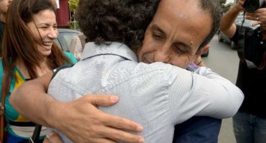 Ali Anouzla right hugs a relative after he is freed on bail in Rabat on October 25, 2013.  By Fadel Senna AFP