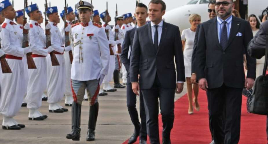 Moroccan King Mohammed VI R walks alongside French President Emmanuel Macron as they review the honour guard upon the latter's arrival in Rabat on June 14, 2017.  By ALAIN JOCARD POOLAFP