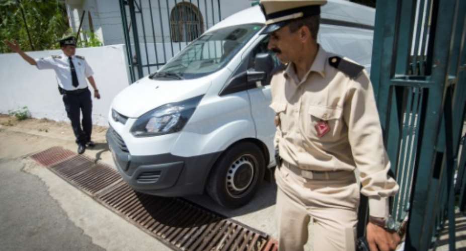 Moroccan security personnel stand guard as a car transporting the suspected killers leaves the court in Sale on May 16.  By FADEL SENNA AFPFile
