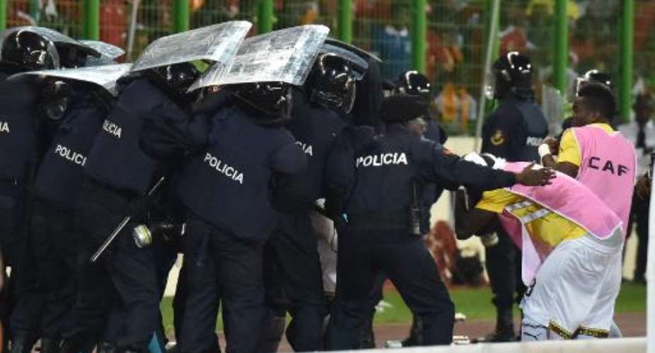 Ghana's national football team players leave the pitch protected by riot police at the half-time of the 2015 African Cup of Nations semi-final football match between Equatorial Guinea and Ghana in Malabo, on February 5, 2015.  By Issouf Sanogo AFP