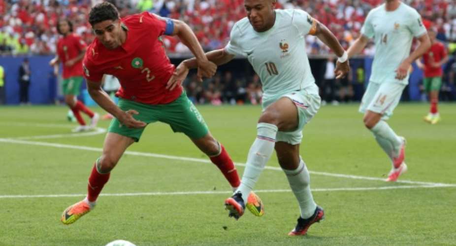 Morocco defender Achraf Hakimi (L) and France forward Kylian Mbappe fight for the ball during a World Cup quarter-final..  By Odd ANDERSEN (AFP)