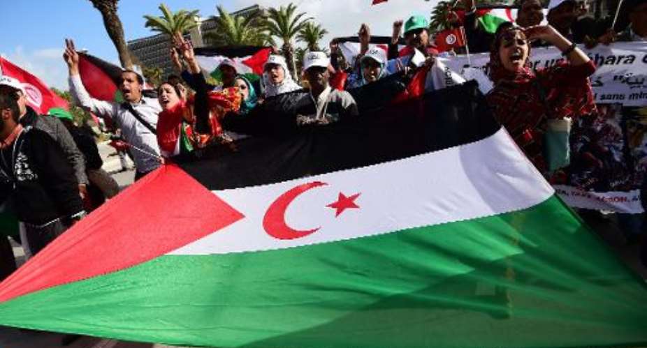 People deploy a flag of the Algerian separatist faction, Polisario Front, during a march in Tunis on March 28, 2015.  By Emmanuel Dunand AFPFile