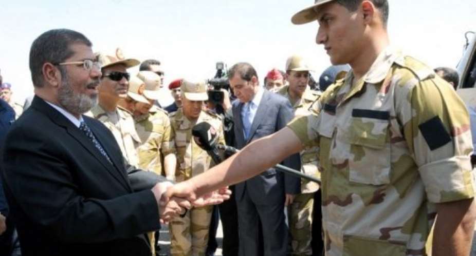 Mohamed Morsi (left) at Almaza airbase on May 22, 2013 greets one of the soldiers held in Sinai by kidnappers.  By  (Egyptian Army/AFP)