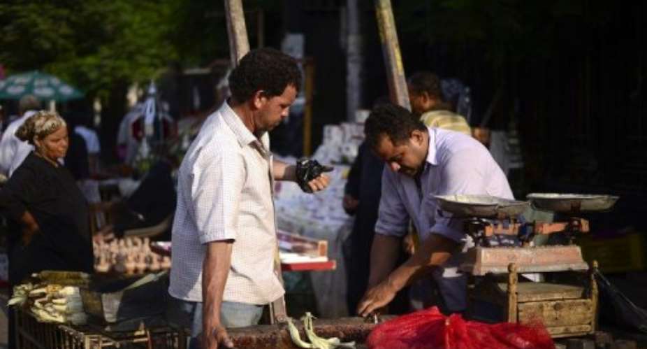 An Egyptian man buys food from a street vendor at an open air market in Cairo.  By Gianluigi Guercia (AFP/File)