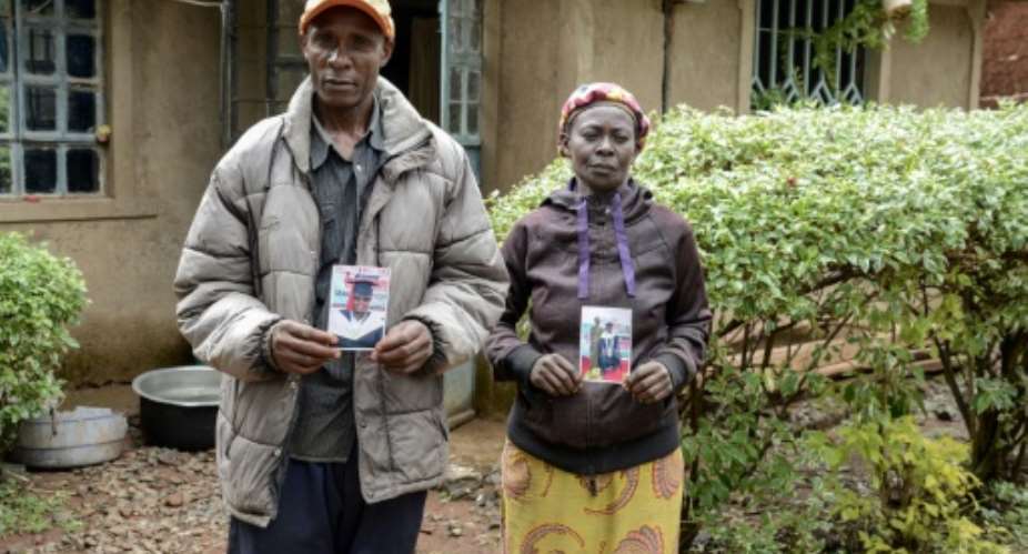 Moses Muyela and Josephine Ngoya hold photos of their son, who reportedly died in Ukraine.  By Brian ONGORO (AFP)