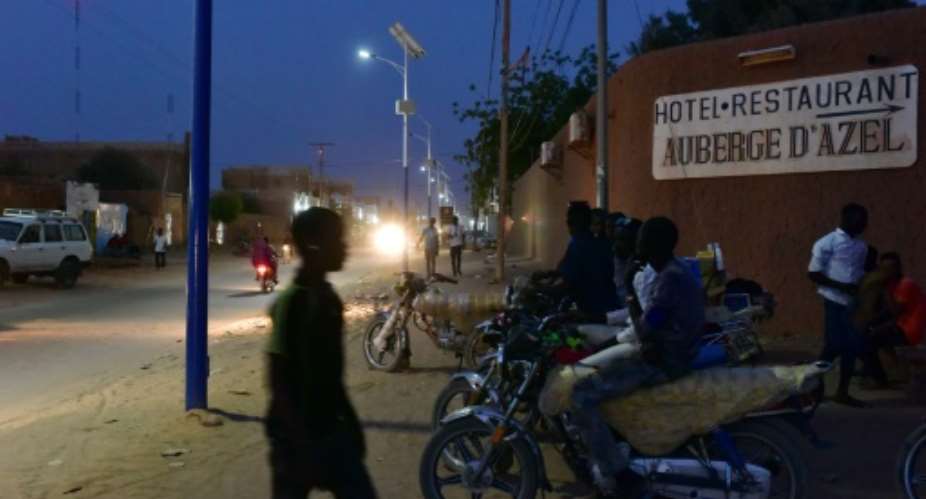 Motorcyle taxi riders wait for customers outside the gates of a hotel in Agadez, northern Niger on April 5, 2017.  By ISSOUF SANOGO AFPFile