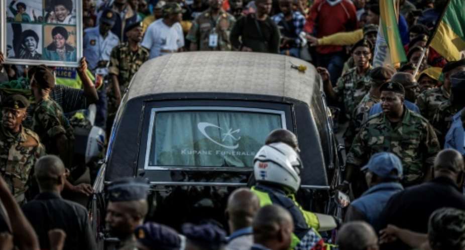 Mourners line the streets of Soweto as a hearse carrying the body of Winnie Mandela makes its way through the township.  By GULSHAN KHAN AFP