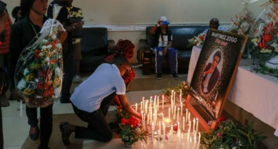 Mourners place candles before a portrait of Cameroon journalist Martinez Zogo, after his abduction and killing a year ago.  By Daniel Beloumou Olomo AFPFile