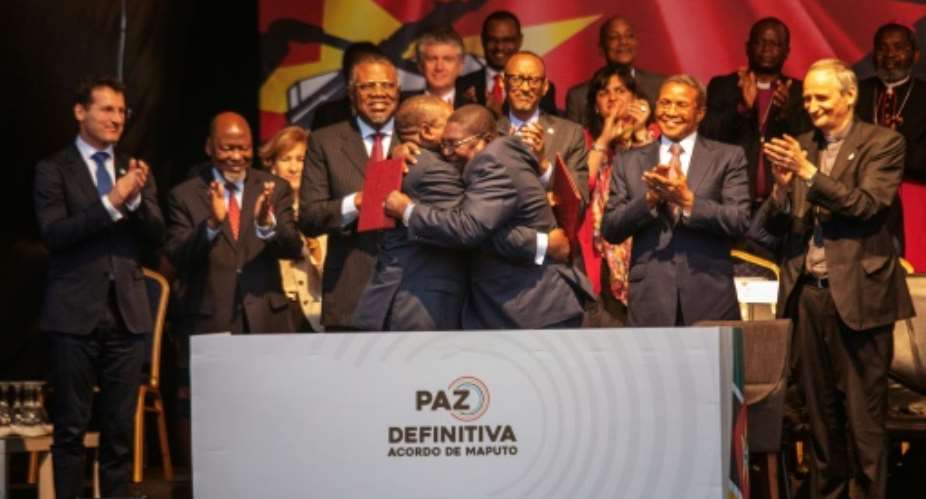 Mozambique's President Filipe Nyusi and Renamo leader Ossufo Momade hug after signing the landmark peace agreement on August 6.  By STRINGER AFPFile