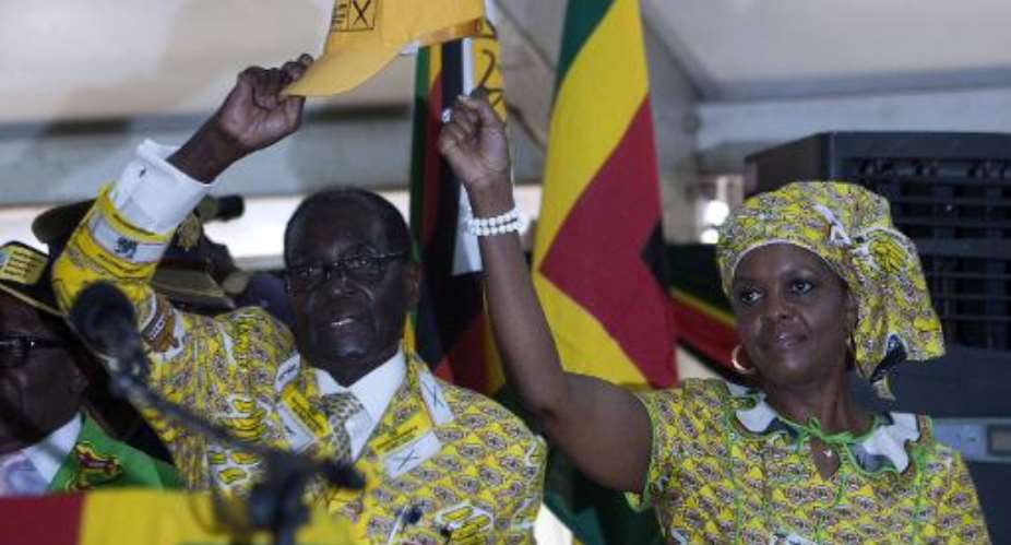 Robert Mugabe left and his wife Grace greet delegates at the conference of his Zanu-PF party in Harare on December 4, 2014.  By Jekesai Njikizana AFP