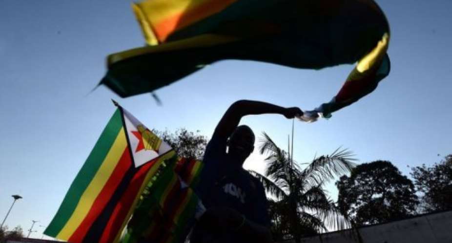 A vendor sells flags on a street in Harare on August 21, 2013, the eve of President Mugabe's inauguration ceremony.  By Alexander Joe AFP
