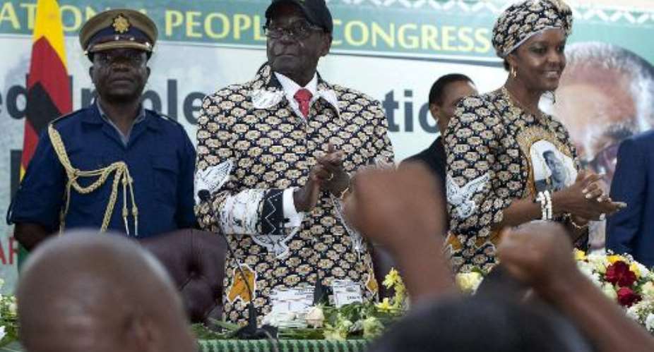 Zimbabwe President  Robert Mugabe with his wife Grace celebrates his re-election unopposed as the leader of Zanu PF for the next five years in Harare on December 6, 2014.  By Jekesai Njikizana AFPFile