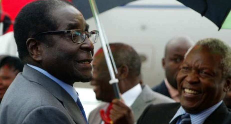 Robert Mugabe appeared healthy as he walked off his charter plane in Harare.  By Jekesai Njikizana AFP