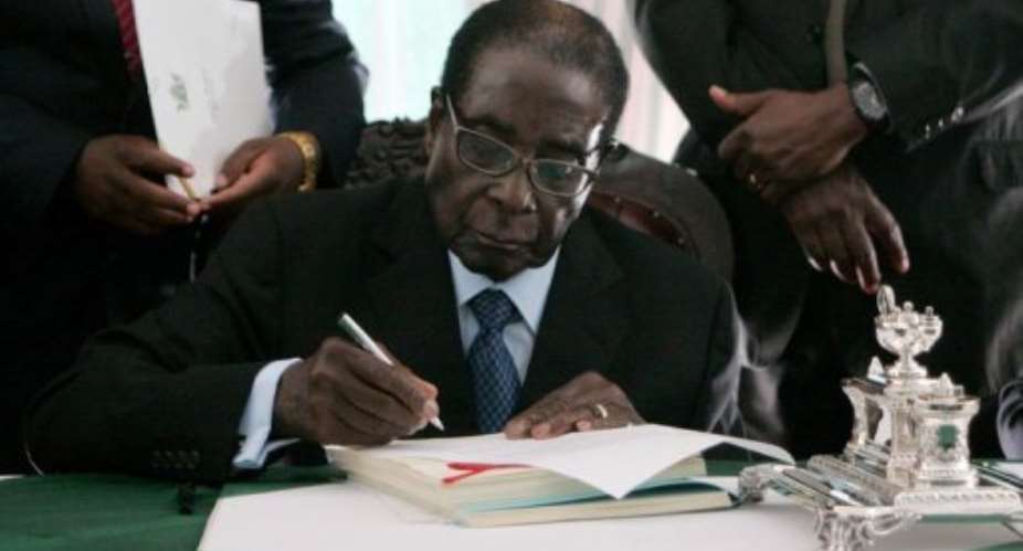 Zimbabwe President Robert Mugabe signs into law Zimbabwes new constitution at the State House in Harare on May 22 2013.  By Jekesai Njikizana (AFP)