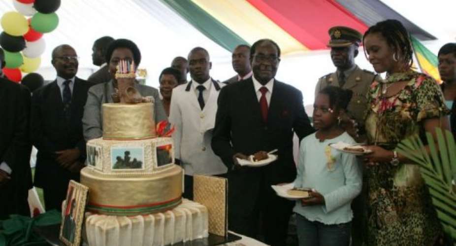 Zimbabwe President Robert Mugabe 4th R with his birthday cake at celebrations at the State House on February 20, 2013.  By Jekesai Njikizana AFP