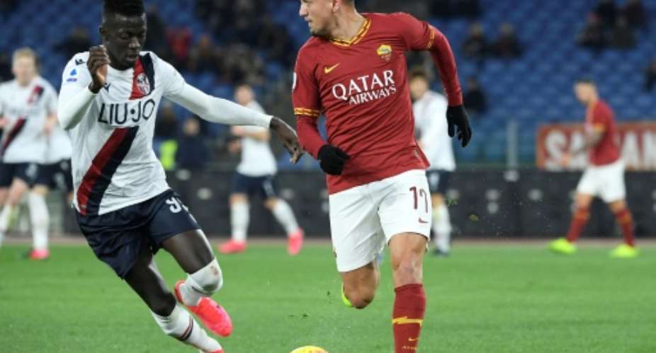 Musa Barrow L of Bologna pursues Cengiz Under of Roma.  By Filippo MONTEFORTE AFP
