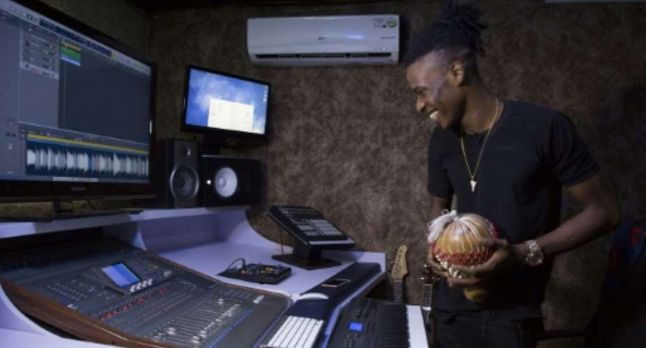 Music producer Chris Alvin Sunday, aka Krizbeatz, smiles while working at his recording studio in Lagos. Two decades ago, Fela Kuti paved the way for Nigerias internationally-acknowledged music scene today.  By EMMANUEL AREWA (AFP)