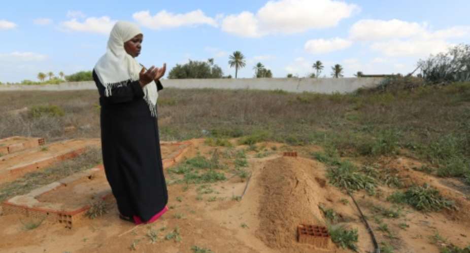 Nadia Borji recites the Koran in a cemetery, in the town of Sedghiane, on the resort island of Djerba on October 22, 2018, a black Tunisian and part of a minority that is barely visible in the north African country.  By FATHI NASRI AFP