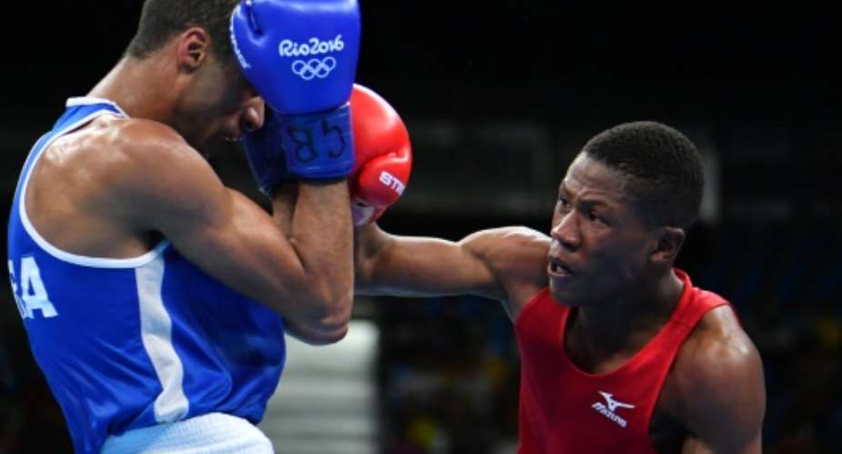 Namibia's Jonas Junias Jonas R punches France's Hassan Amzile during the men's light welter match at the Rio Games on August 11, 2016.  By Yuri Cortez AFP