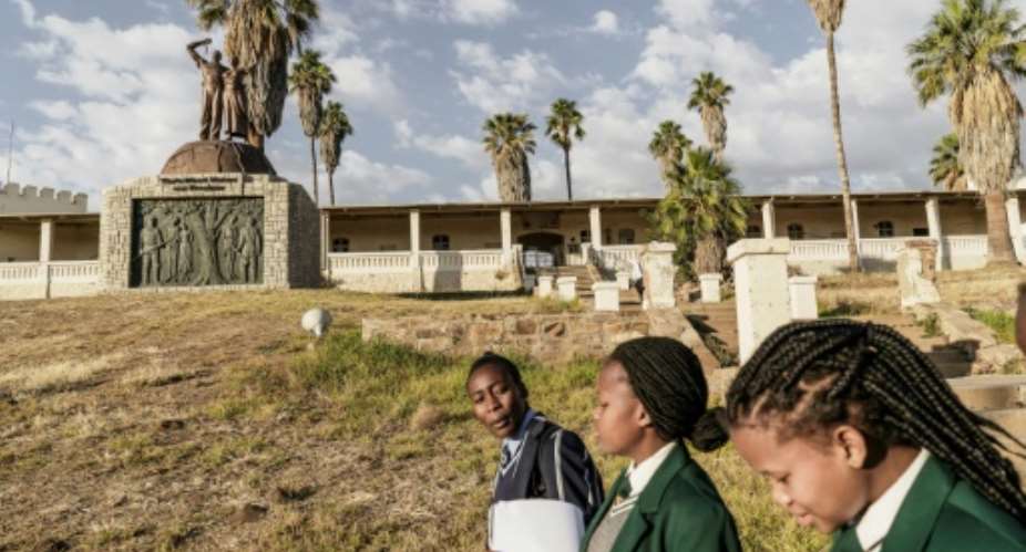Namibian schoolgirls walk by a memorial in tribute to the victims of the alleged genocide committed by German forces against Herero and Nama people in 1904.  By GIANLUIGI GUERCIA AFP
