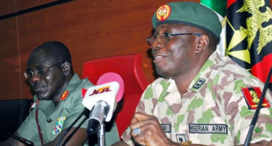 New head of the five-nation Multi-National Joint Task Force MNJTF Major-General Iliya Abbah R speaks flanked by his predecessor Nigerian army chief Major General Tukur Buratai  during a handover ceremony in Abuja on July 31, 2015.  By  AFP