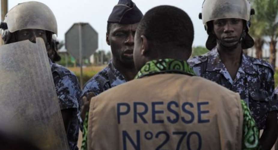 Security prevents journalists and others from protesting in front of the Palais des Congres in Lome on February 19, 2013.  By Daniel Hayduk (AFP)