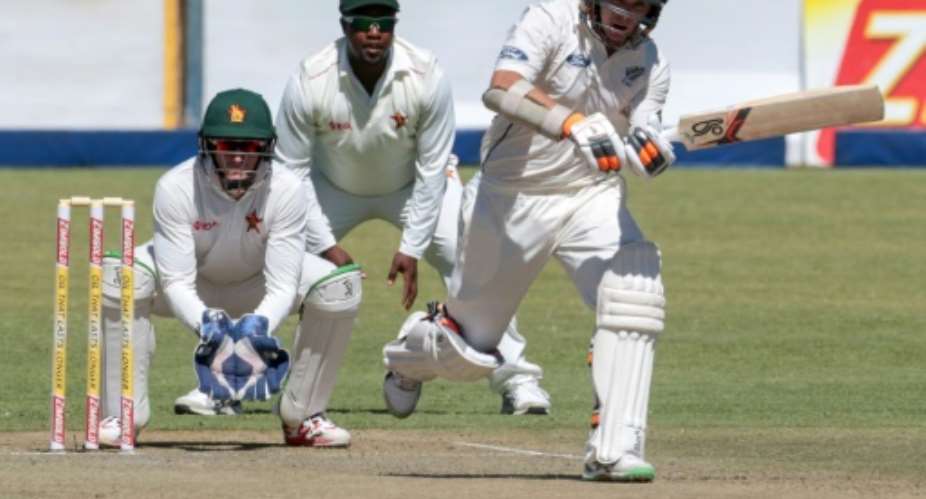 New Zealand batsman Tom Latham R plays a shot as Zimbabwe wicketkeeper PJ Moor L looks on during the first day of the second Test at the Queens Sports Club in Bulawayo, on August 6, 2016.  By Jekesai Njikizana AFP
