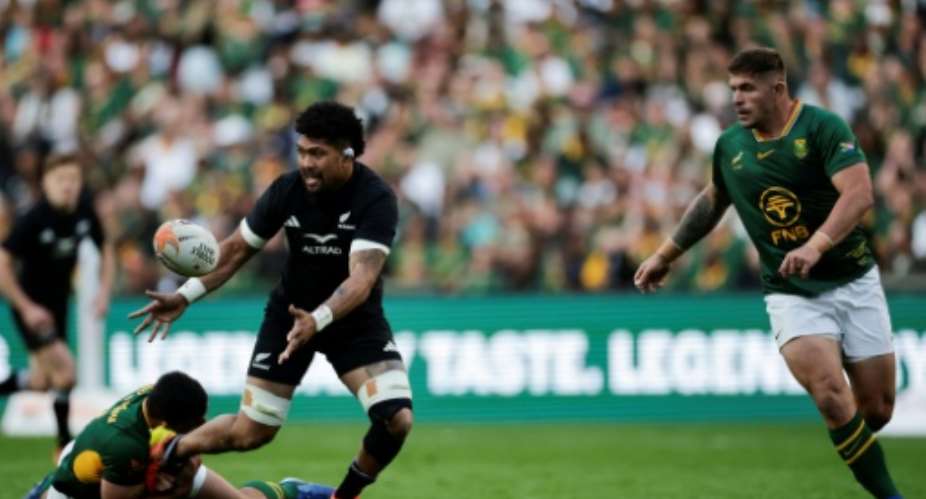 New Zealand captain Ardie Savea (L) passes the ball during the first Test against South Africa in Johannesburg..  By PHILL MAGAKOE (AFP)