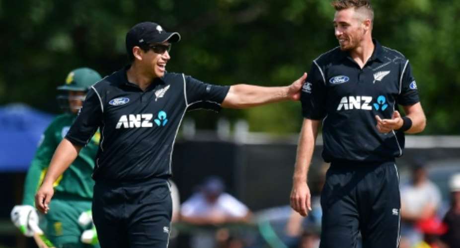 New Zealand's Tim Southee R receives a pat on the back from teammate Ross Taylor during their second ODI match against South Africa, at the Hagley Park Oval in Christchurch, on February 22, 2017.  By Marty Melville AFP