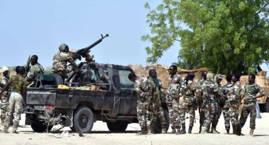 Niger soldiers, working with Chadian troops to fight Boko Haram, gather by a military vehicle on May 25, 2015 in Malam Fatori, in northern Nigeria.  By Issouf Sanogo AFPFile
