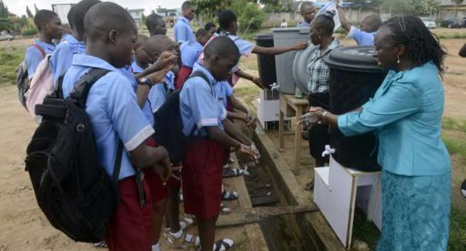 A teacher demonstrates washing procedures to pupils prevent the spread of the Ebola virus at a school in Lagos on October 8, 2014.  By Pius Utomi Ekpei AFPFile