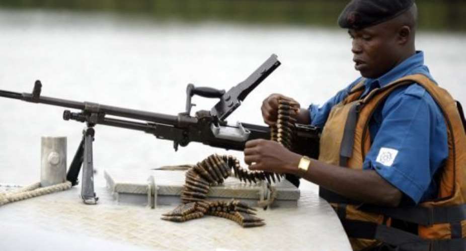 A naval officer assembles his machine gun before starting a patrol of the Niger Delta region in 2004.  By Pius Utomi Ekpei AFPFile