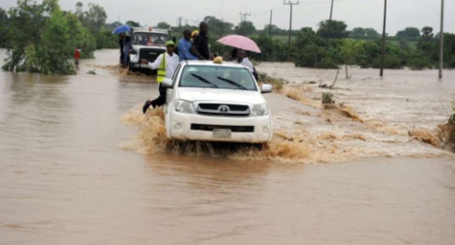 Travellers are driven in trucks through a flooded road that leads to Kaduna Airport in Kaduna, northwest Nigeria on July 7, 2013.  By Pius Utomi Ekpei AFPFile