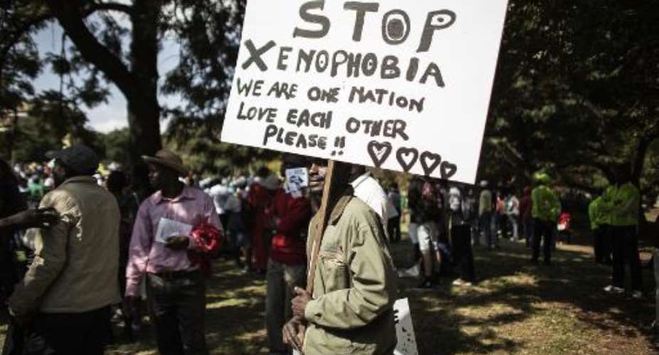 A demonstrator holds an anti-xenophobia poster in Johannesburg on April 23, 2015.  By Gianluigi Guercia AFPFile