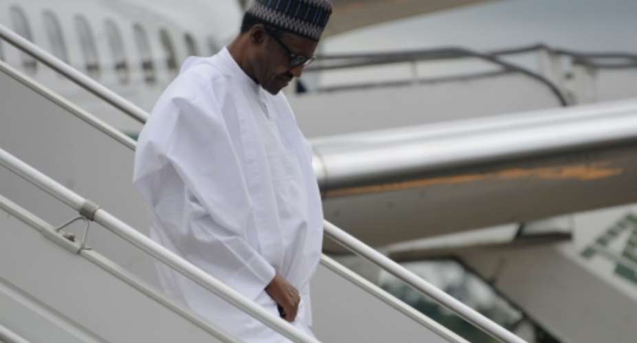 President of Nigeria Muhammadu Buhari walks down the steps of his aircraft following his arrival at the airport in Yaounde on July 29, 2015.  By Reinnier Kaze AFPFile