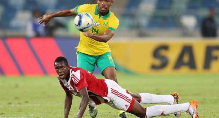 Thulani Hlatshwayo of South Africa challenges Assan Ceesay of Gambia on the ground during their Group M, 2017 Africa Cup of Nations qualifying football match on June 13, 2015 in Durban.  By Anesh Debiky AFP