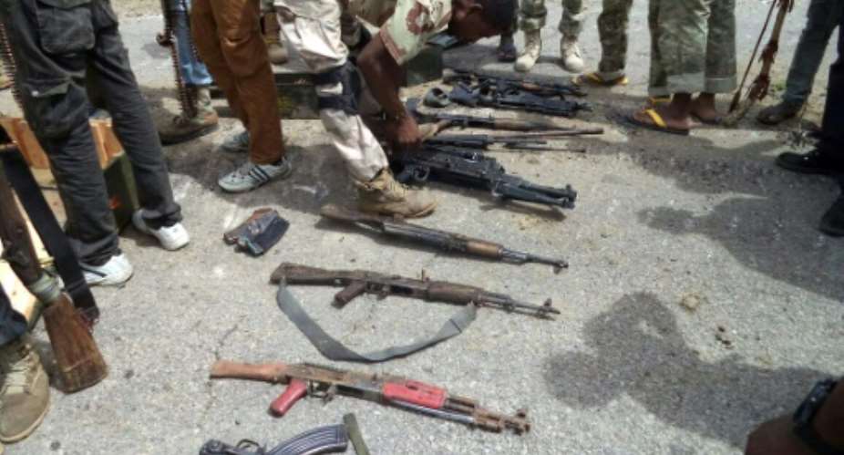Nigerian soldiers display a cache of weapons seized from Boko Haram fighters following clashes near the northeastern town of Dikwa, on July 26, 2015.  By Nigerian Army AFPFile