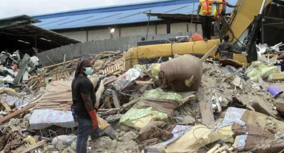 Rescue workers clear away mattresses used by occupants of the collapsed guesthouse of the Synagogue Church of All Nations at Ikotun in Lagos on September 17, 2014.  By Pius Utomi Ekpei AFP