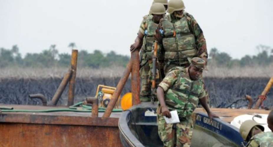 The Joint Take Force inspects a barge seized from oil thieves at Bodo waterways, Ogoniland in Rivers State in 2011.  By Pius Utomi Ekpei AFPFile
