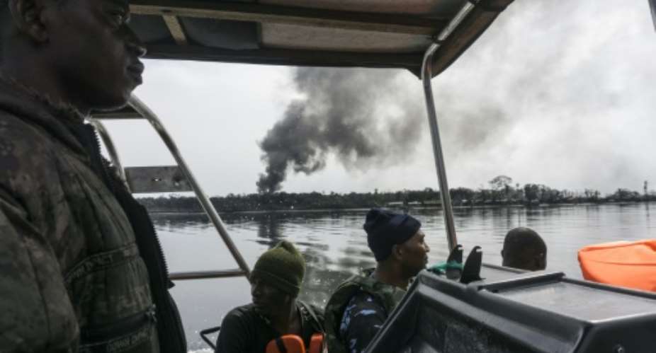 Nigerian Navy forces on the lookout for illegal oil refineries in the Niger Delta region spot the tell-tale signs of billowing black smoke.  By STEFAN HEUNIS AFP