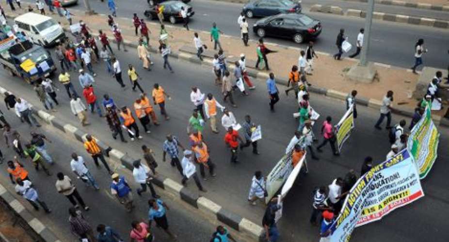 Students and workers carry placards as they march to protest against the suspension of academic activities following a nationwide strike by lecturers in state-owned universities, on August 13, 2013 in Lagos.  By Pius Utomi Ekpei AFPFile